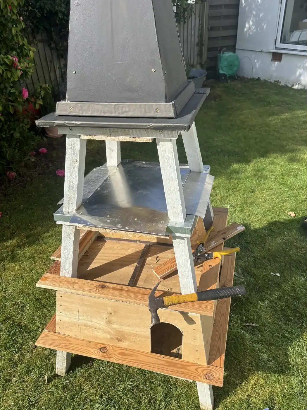 Sheet aluminium landing and feeding platform fitted to the Burns Loft dovecote — doubles as a waterproof roof over the nest boxes. Romford, Essex.